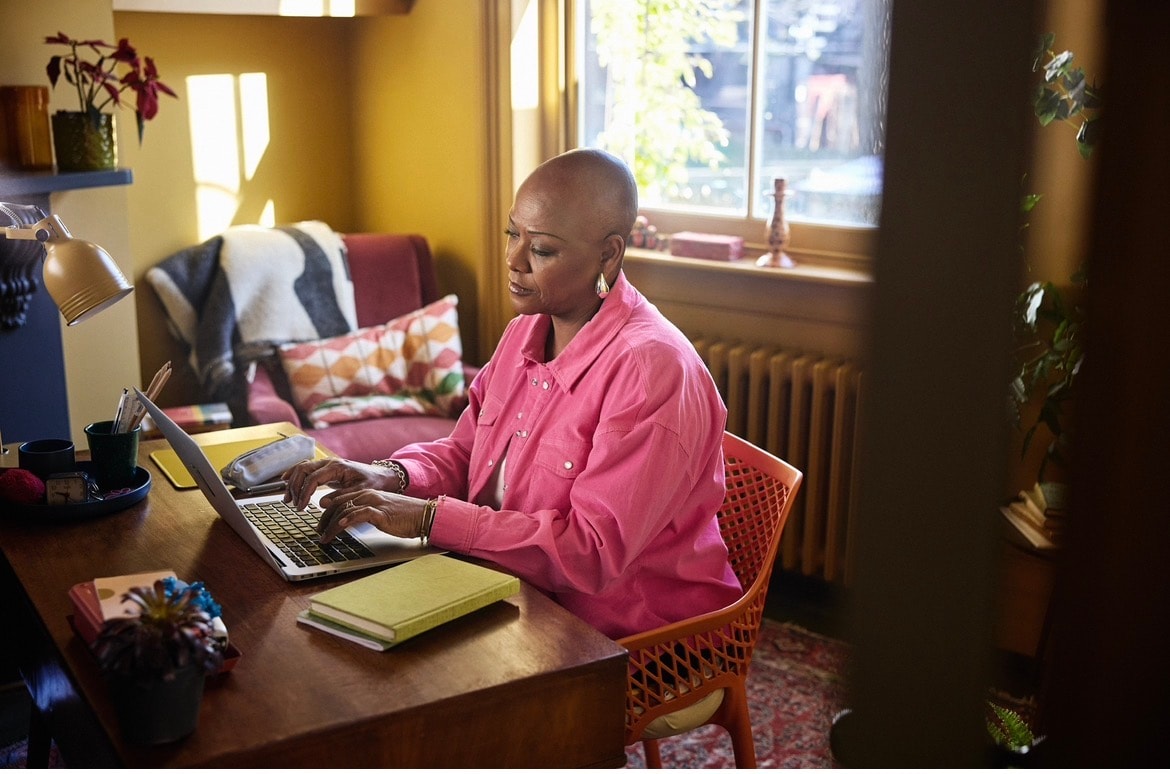 Sharon-Ann Phillips at her desk at home, featured in GSK campaign advert — photo courtesy of Richard Moran/GSK