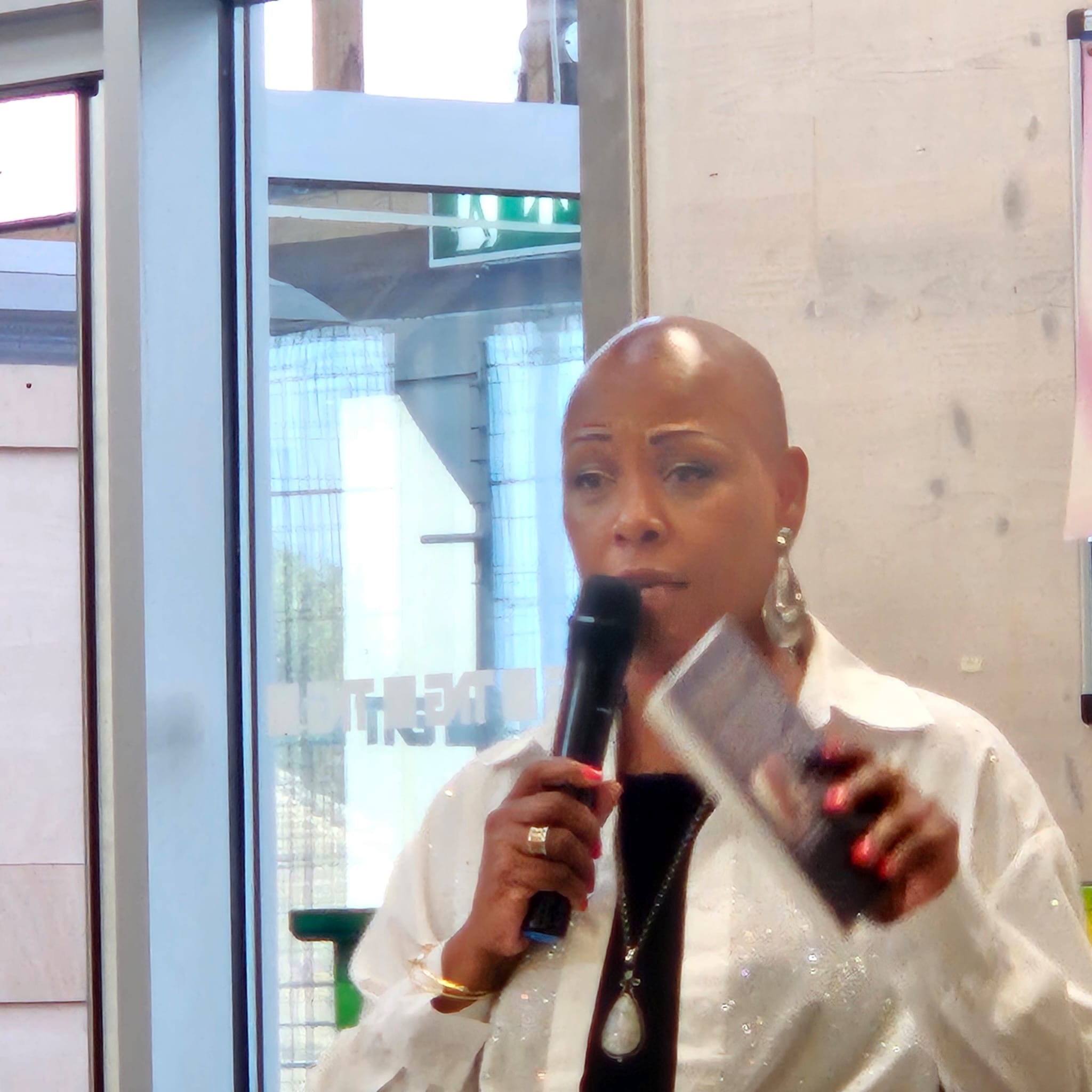 Sharon-Ann Phillips speaking with a microphone at a community event